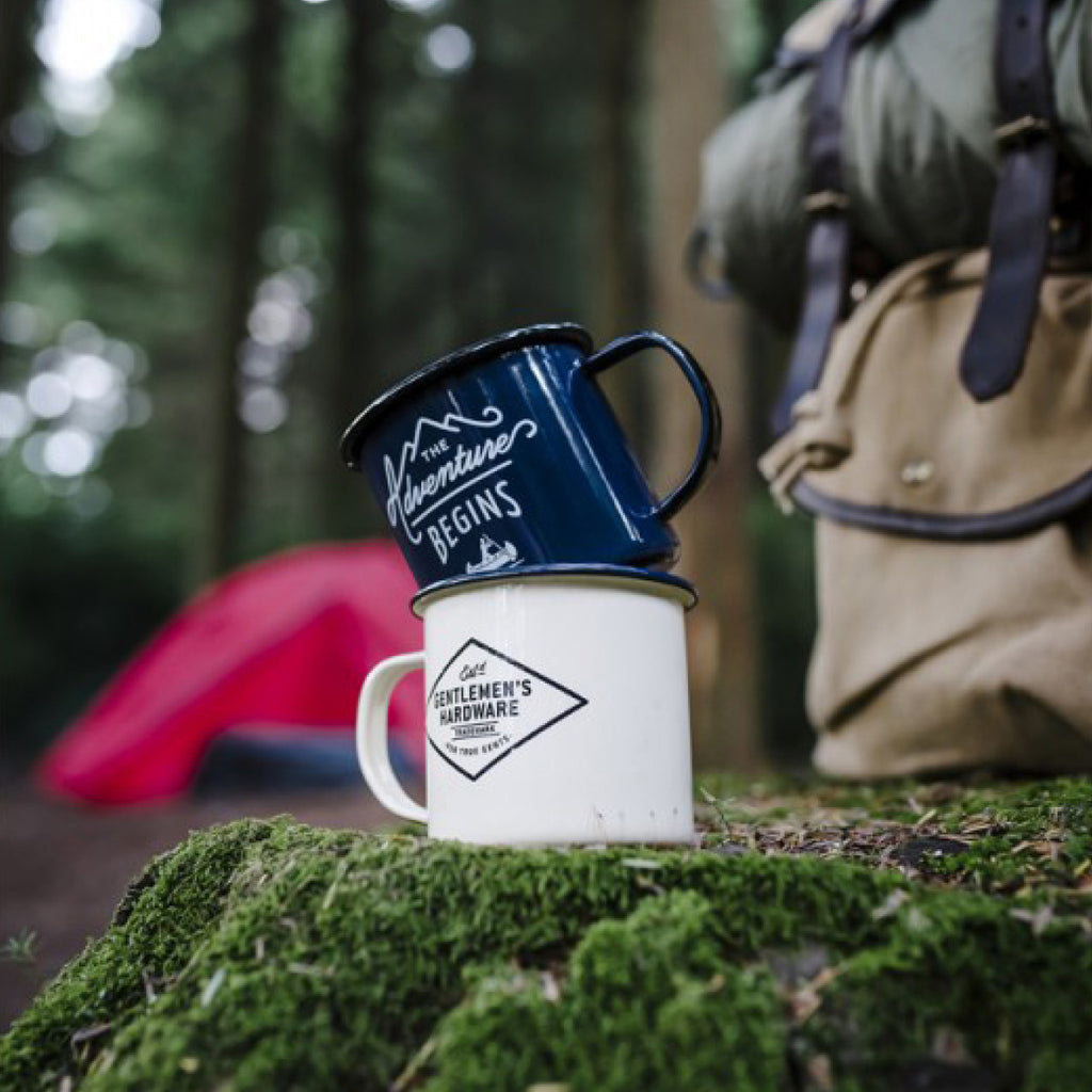 Blue enamel mug with white text "The Adventure Begins"